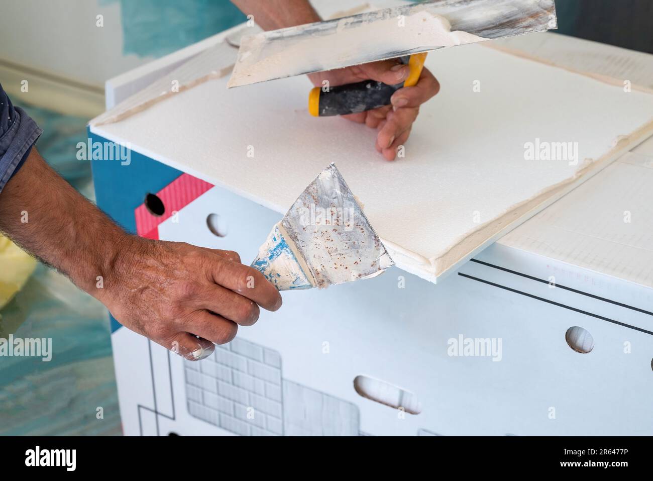 adhesive plaster application of styrofoam ceiling tiles of a home kitchen Stock Photo