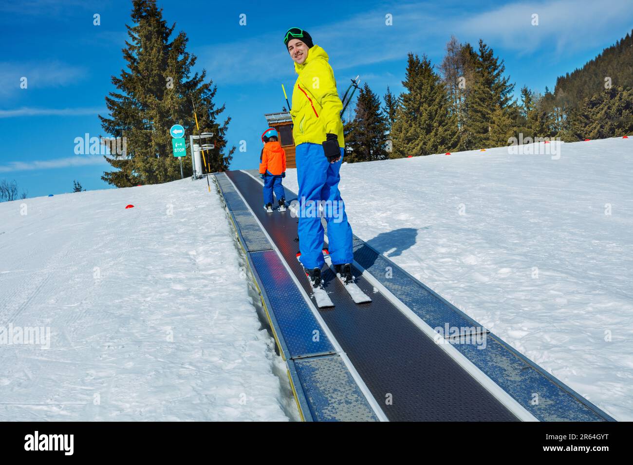 Boy and a dad look back standing on the ski moving walkway Stock Photo
