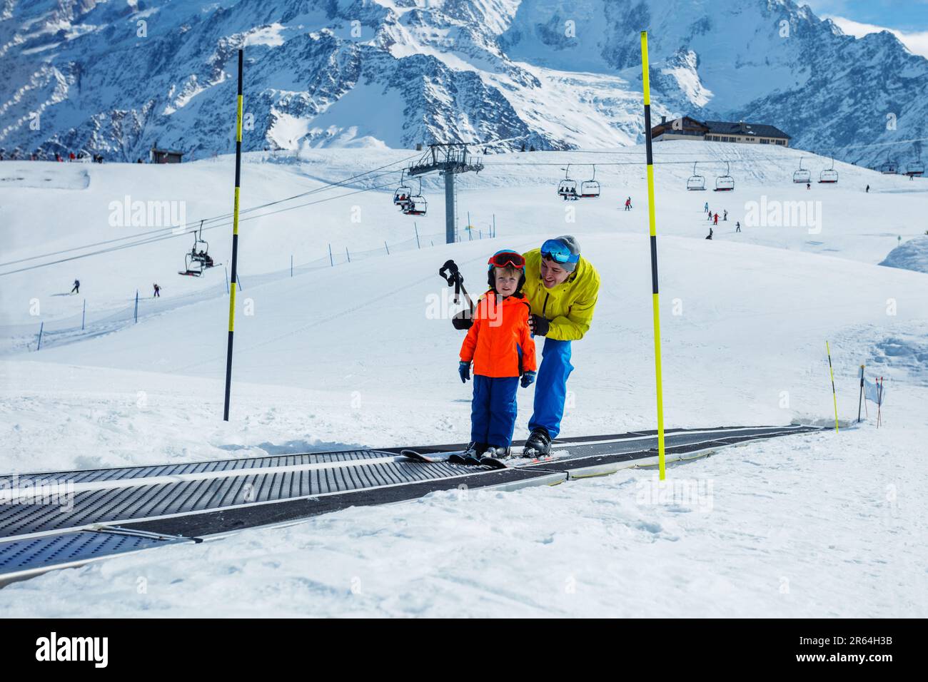 Boy and a father on the ski moving walkway belt at skiing school Stock Photo