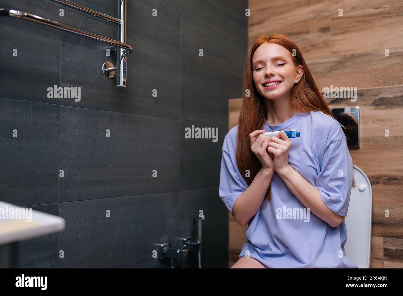 Happy excited young woman delighted with positive pregnancy kit test