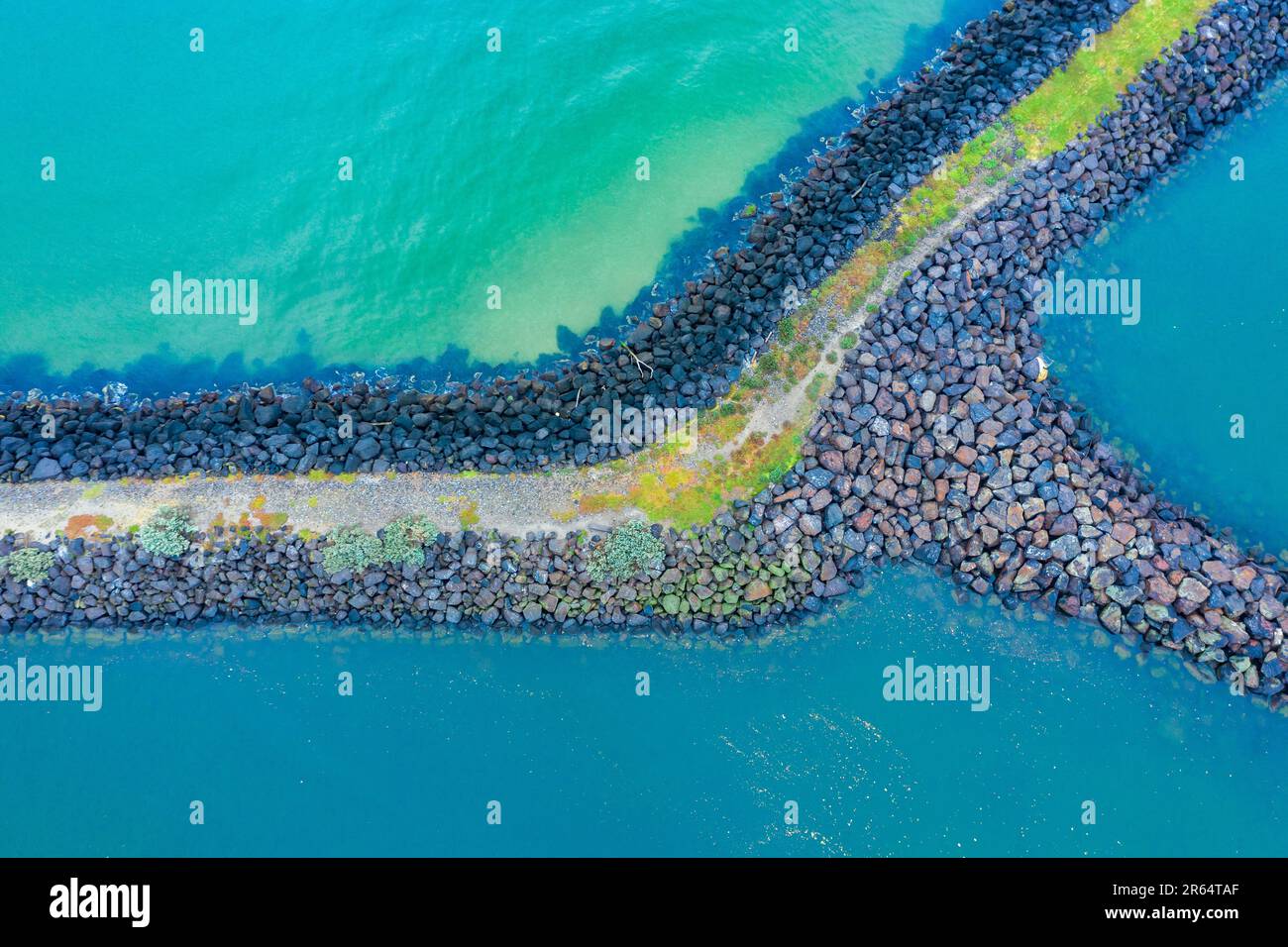 Aerial view of a rocky breakwater surrounded by turquoise ocean at St