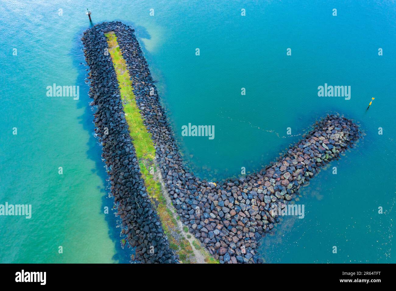 Aerial view of a rocky breakwater surrounded by turquoise ocean at St