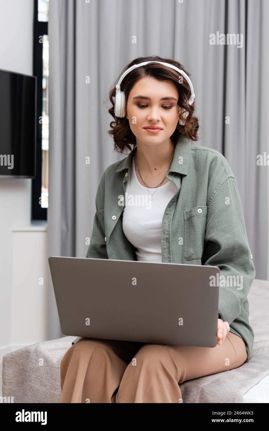 young woman with wavy hair, casual clothes and wireless