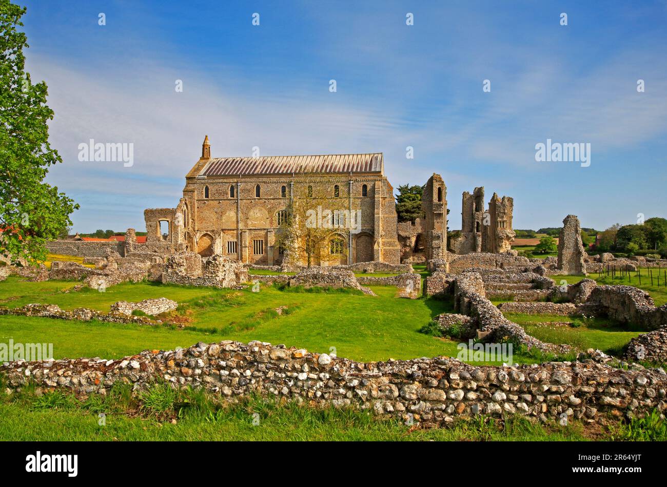 A view from the south of the ruins of Binham Priory with the parish Church of St Mary and the Holy Cross at Binham, Norfolk, England, United Kingdom. Stock Photo