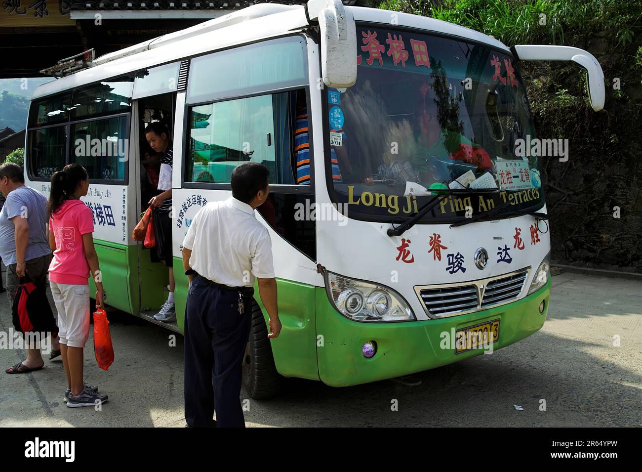 龙胜镇 (龙胜县) 中國 Longsheng, China; Passengers boarding a small Chinese bus; Passagiere steigen in einen kleinen chinesischen Bus; 中国の小型バスに乗車する乗客 Stock Photo