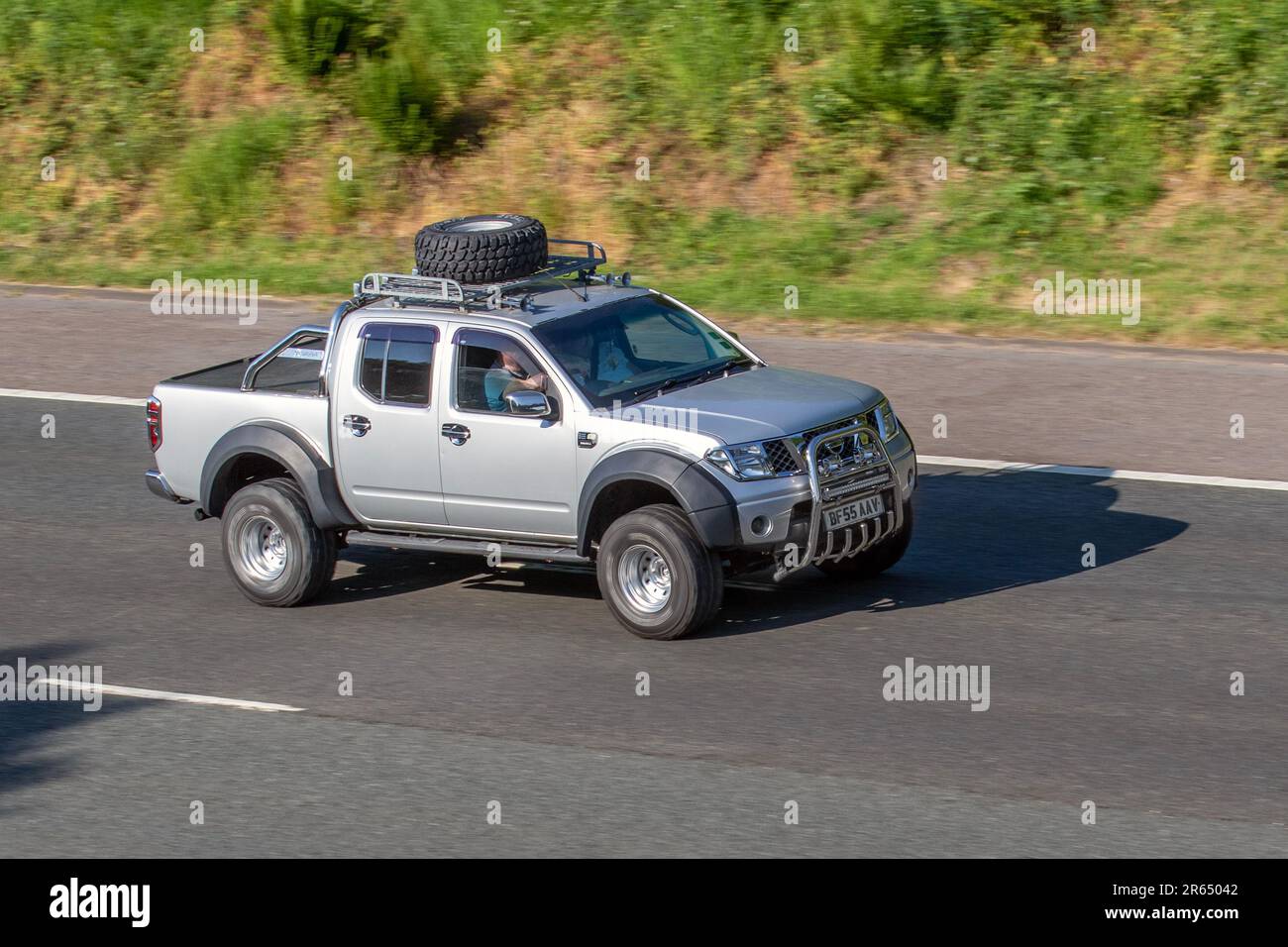 2005 Silver Nissan Navara DCI SE with spare tyre on roof rack; travelling on the M61 motorway, UK Stock Photo