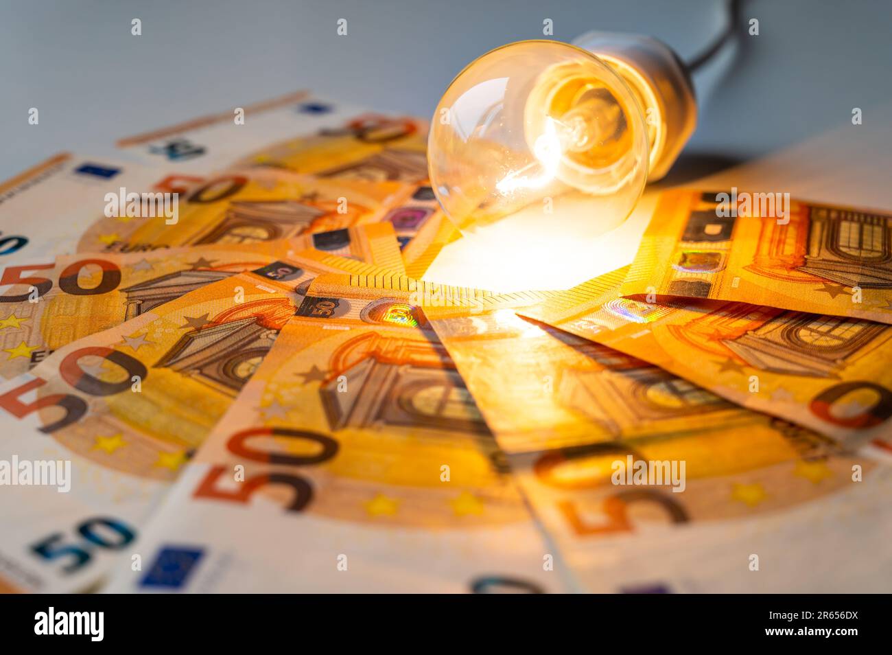 Light bulb turned on, with Euro banknotes around. Increase in
