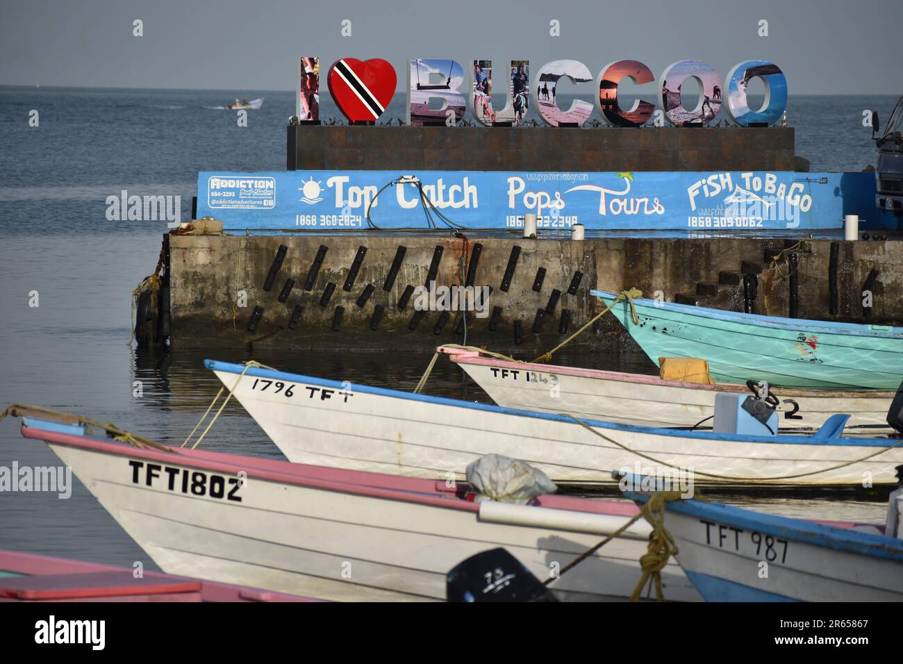 Buccoo, Tobago - June 4, 2023 - Fishing boats in front of the 'I Love Buccoo' sign in Buccoo. Stock Photo