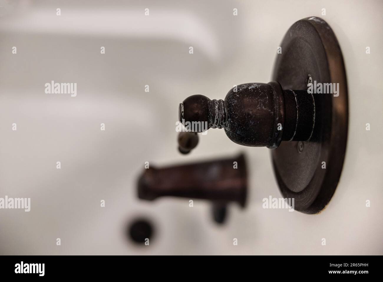 An oil rubbed bronze shower handle that needs to be cleaned from a