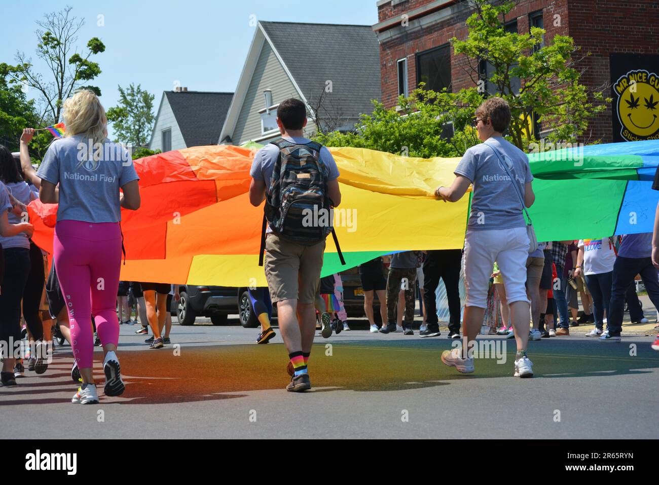 People carrying a large rainbow flag as they march in the annual Buffalo Pride Parade. Stock Photo