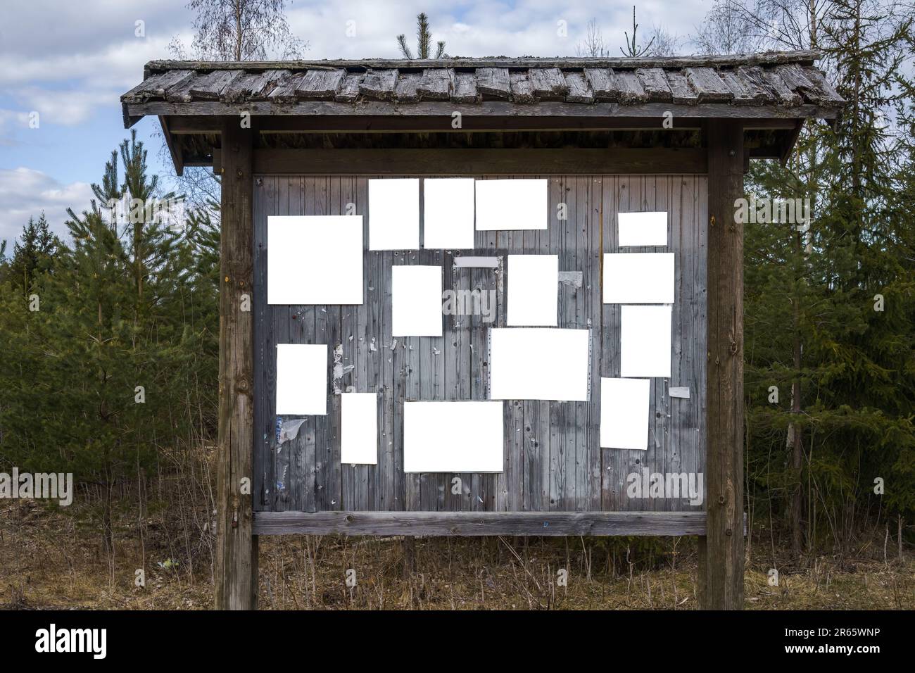 Old wooden bulletin board outdoors with empty white notes. Stock Photo
