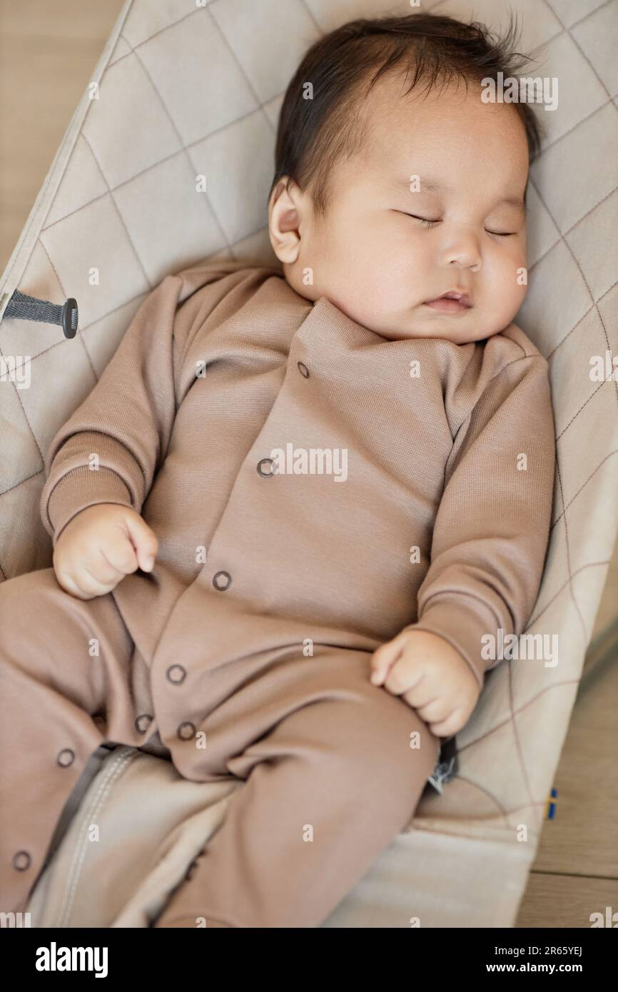 Vertical image of cute Asian baby boy sleeping on his bed Stock Photo