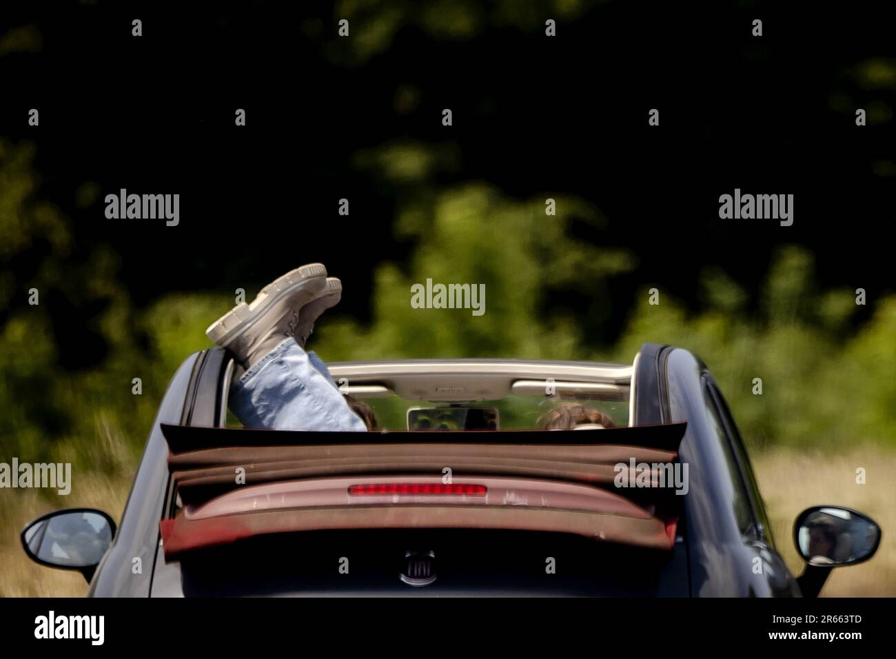 UTRECHT - Two shoes stick out of a convertible with an open roof. The temperature is expected to rise to high values. ANP ROBIN VAN LONKHUIJSEN netherlands out - belgium out Stock Photo