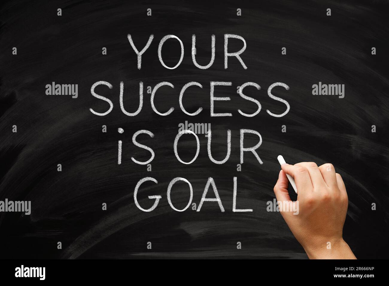 Hand writing inspirational quote Your Success Is Our Goal on blackboard. Concept about leadership, partnership, cooperation, or collaboration. Stock Photo