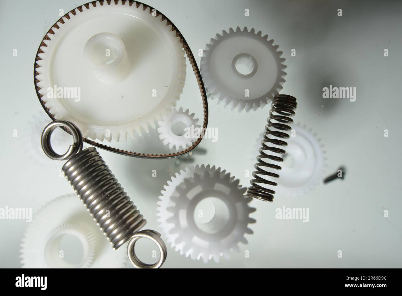 Gear wheels, springs, parts. Plastic gears. Monochrome picture of plastic and metal parts. Creativity from small plastic parts. Printer parts. Stock Photo