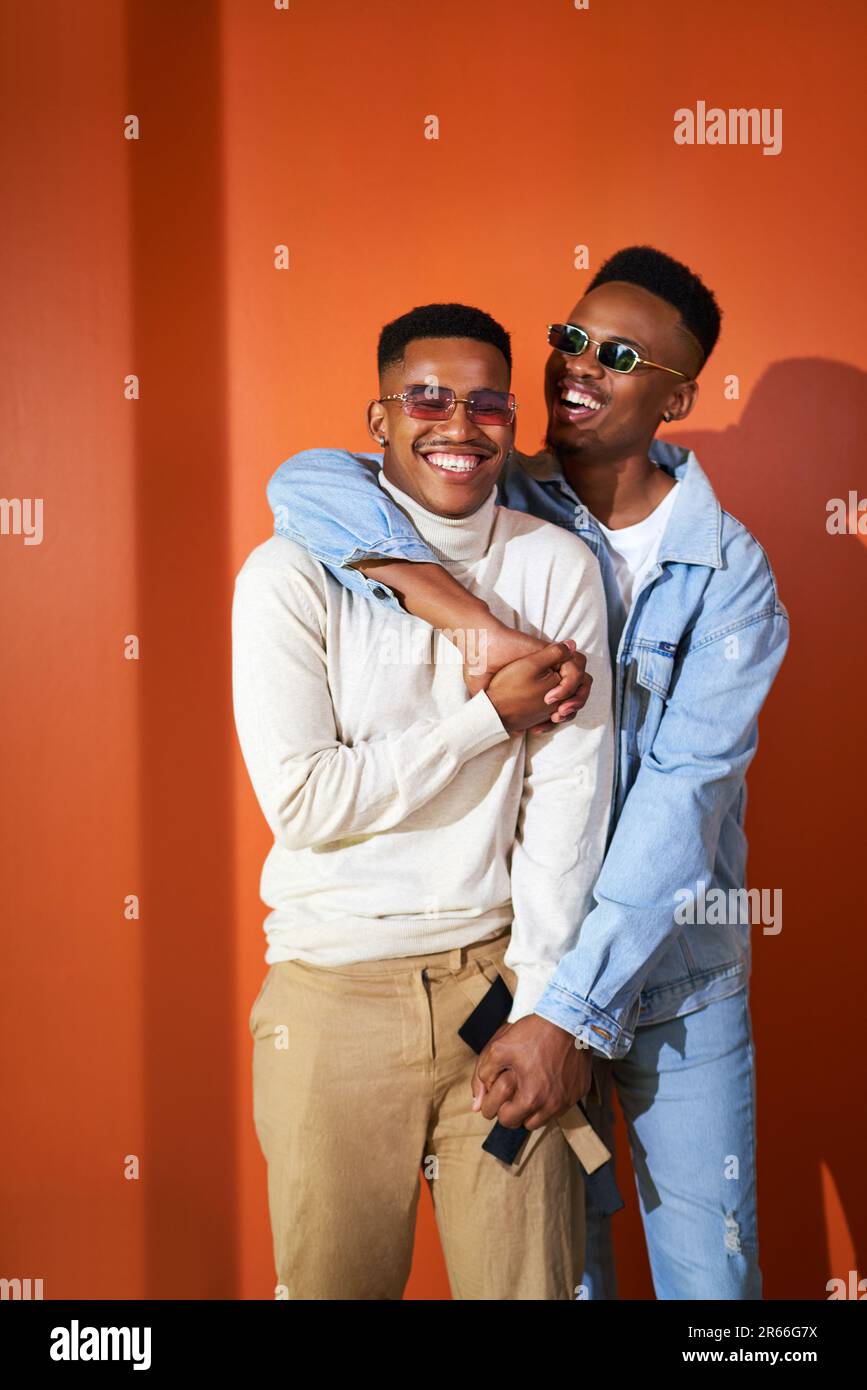 Portrait happy young gay male couple laughing and hugging Stock Photo
