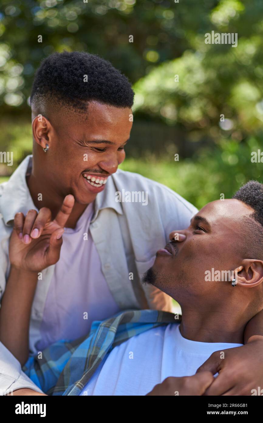 Happy, affectionate young gay male couple laughing and hugging Stock Photo
