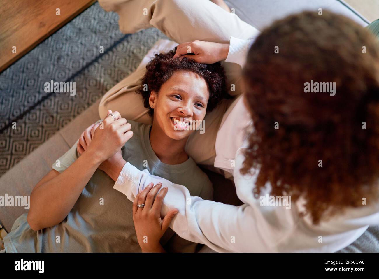 View from above lesbian woman laying in lap of wife on sofa at home Stock Photo