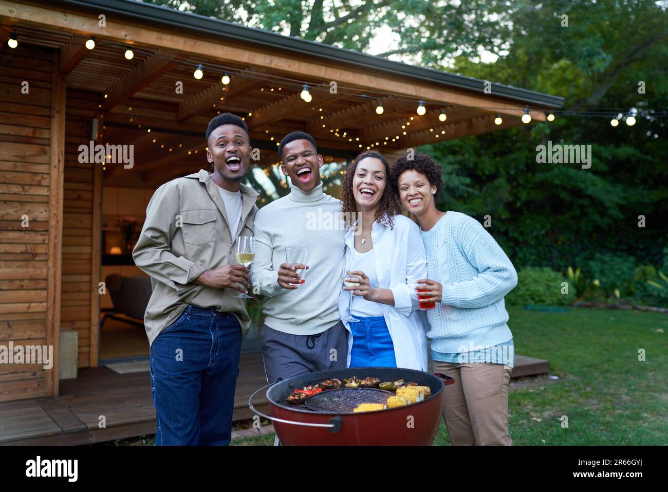 Portrait happy gay couples drinking and barbecuing in summer backyard Stock Photo