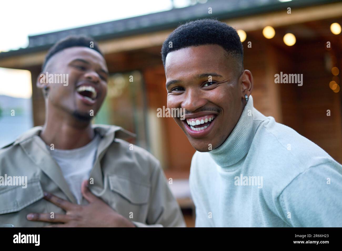 Portrait happy young gay male couple laughing on patio Stock Photo