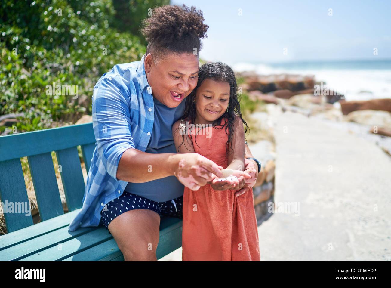 Excited father and daughter looking at seashells on beach boardwalk Stock Photo