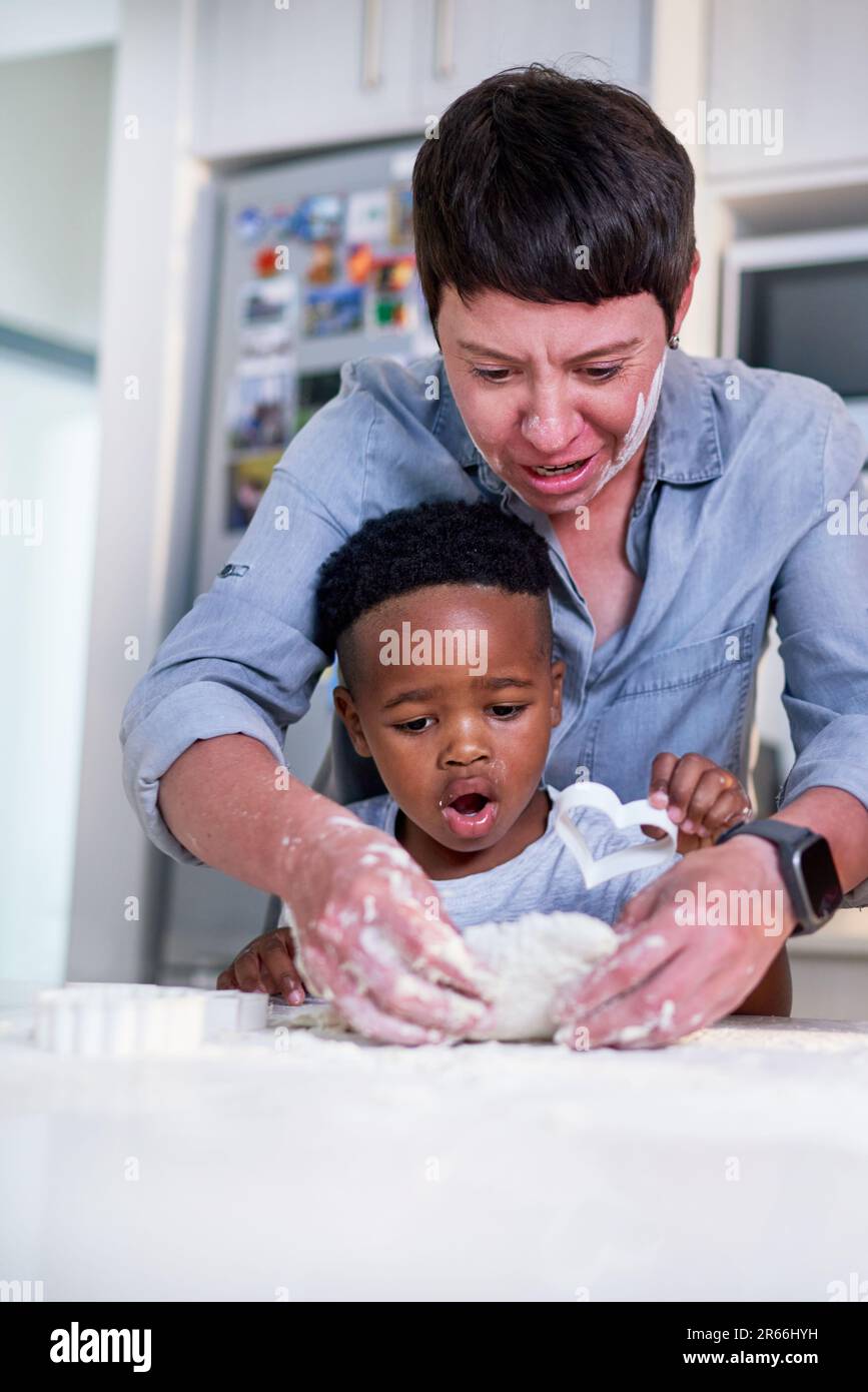 Mother and son baking heart-shape cookies in kitchen at home Stock Photo