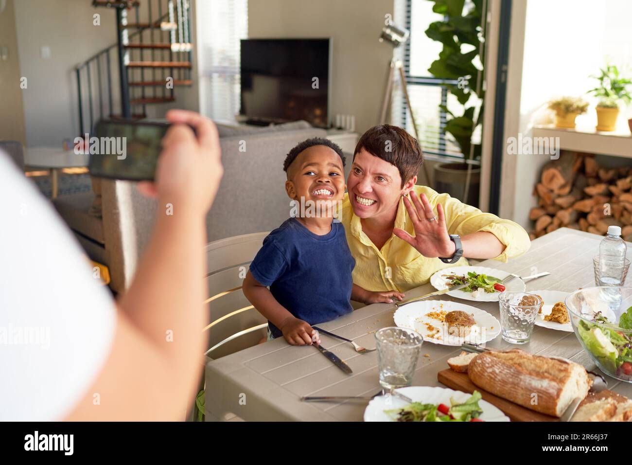 Happy mother and son posing for photo at dinner table Stock Photo