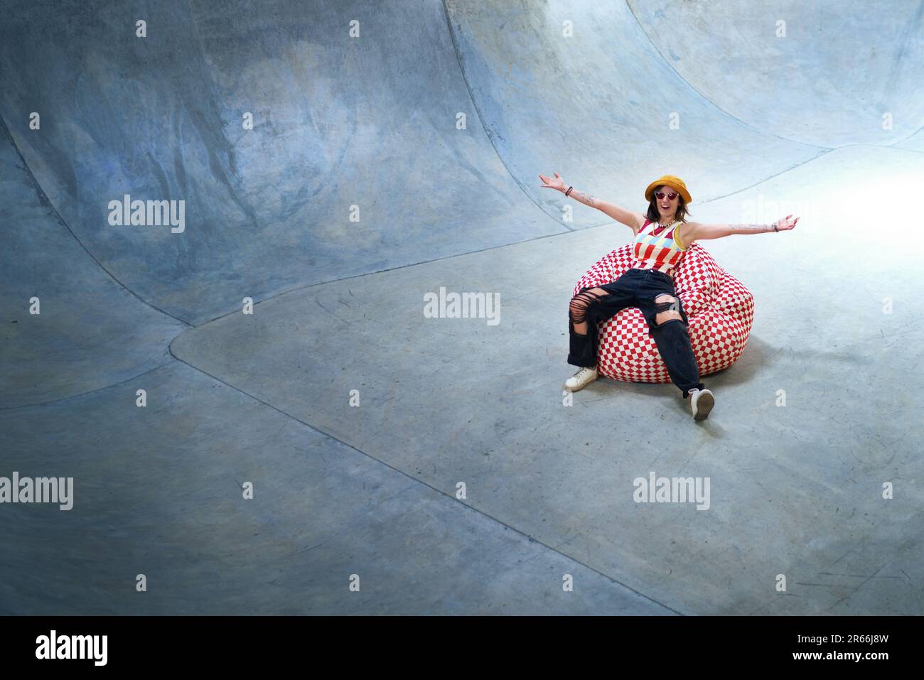 Portrait carefree young woman in beanbag chair on skate ramp Stock Photo