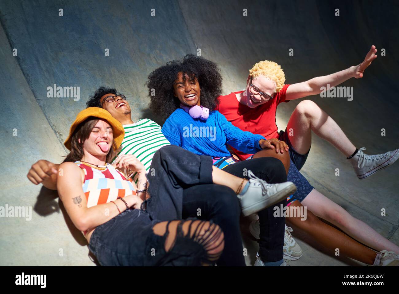 Portrait happy, carefree young friends laughing on sports ramp Stock Photo