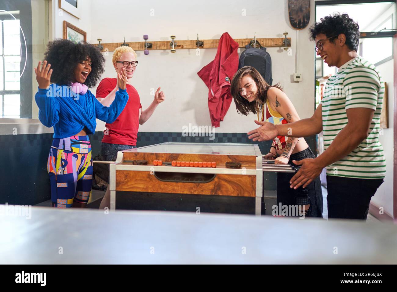 Happy young friends playing foosball in game room Stock Photo