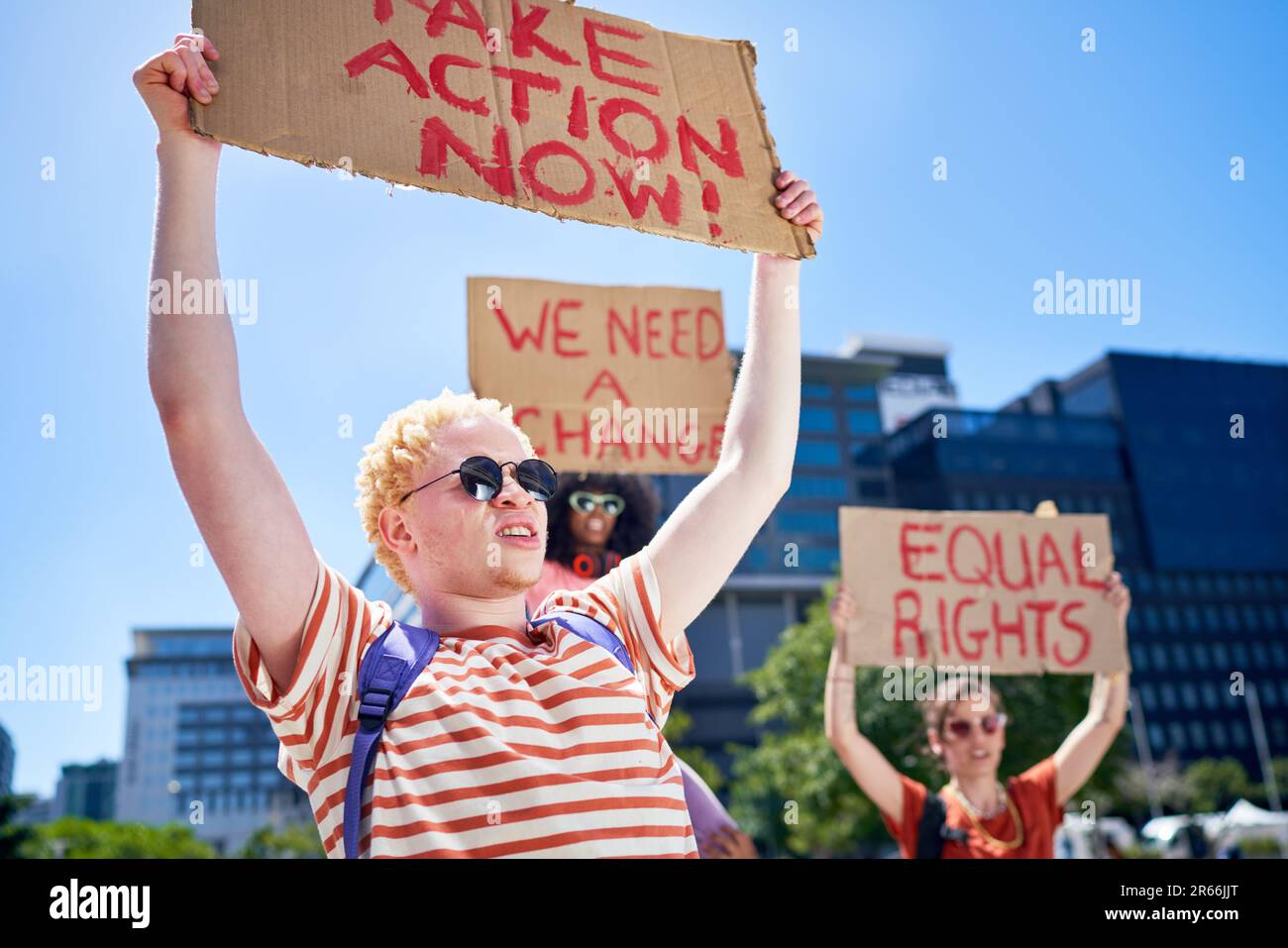 Young protesters holding equal rights signs in sunny city Stock Photo