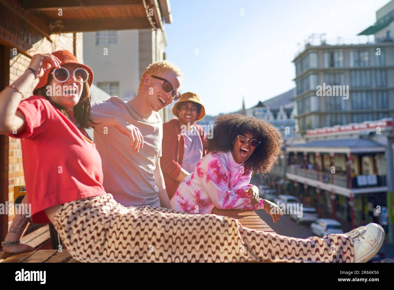 Portrait happy young friends on sunny urban city balcony Stock Photo