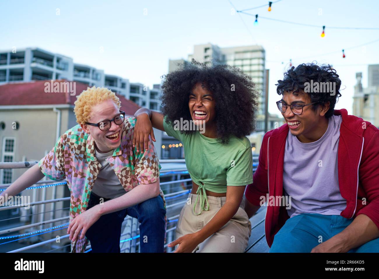 Happy young friends laughing on urban apartment balcony Stock Photo