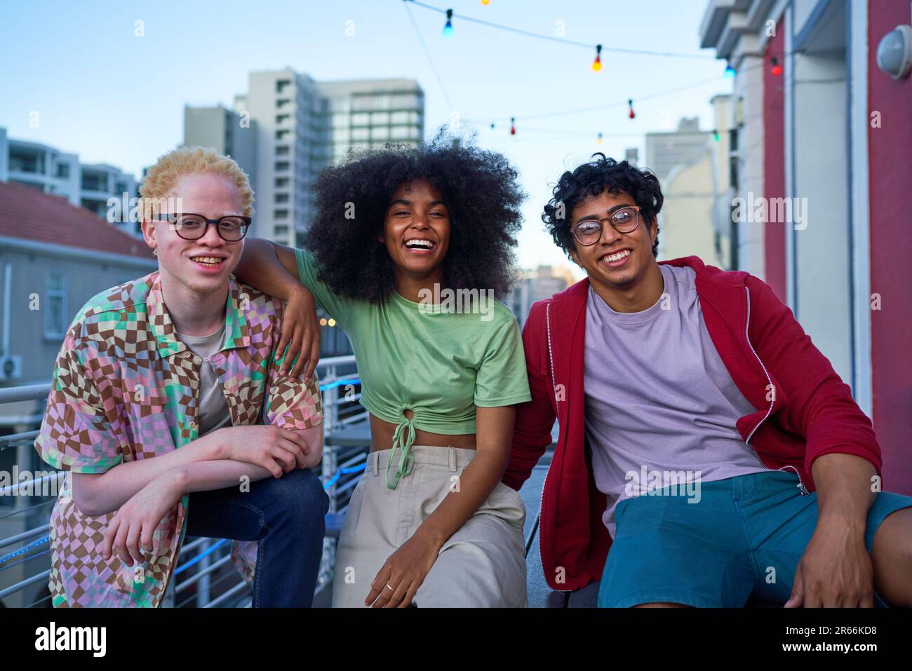 Portrait happy young friends on urban apartment balcony Stock Photo