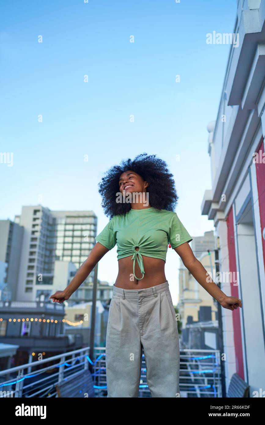 Portrait happy young woman on city balcony Stock Photo