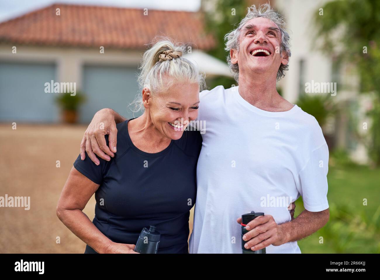 Happy, carefree senior couple with water bottles laughing Stock Photo