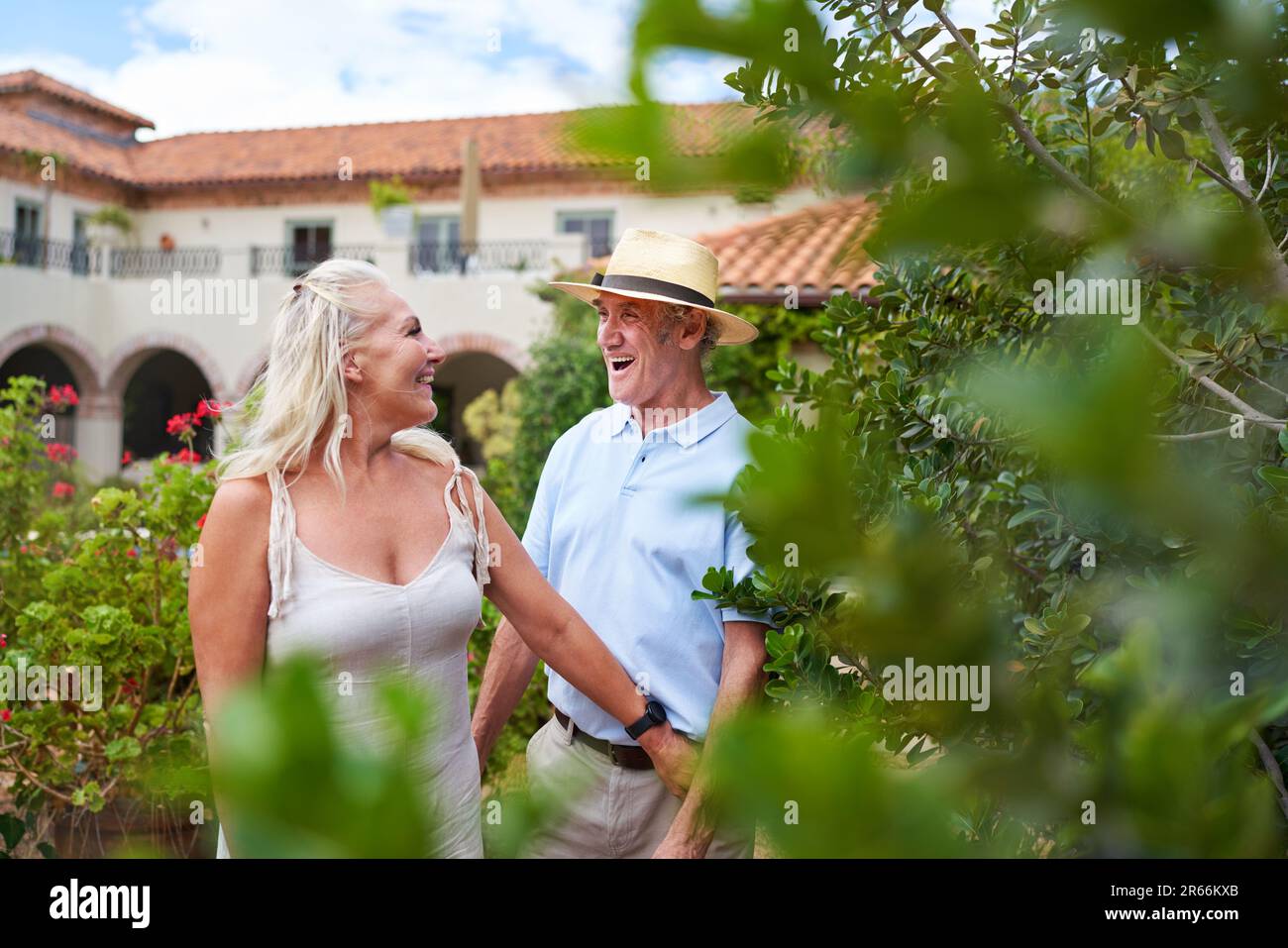 Happy senior couple walking in garden outside summer villa Stock Photo