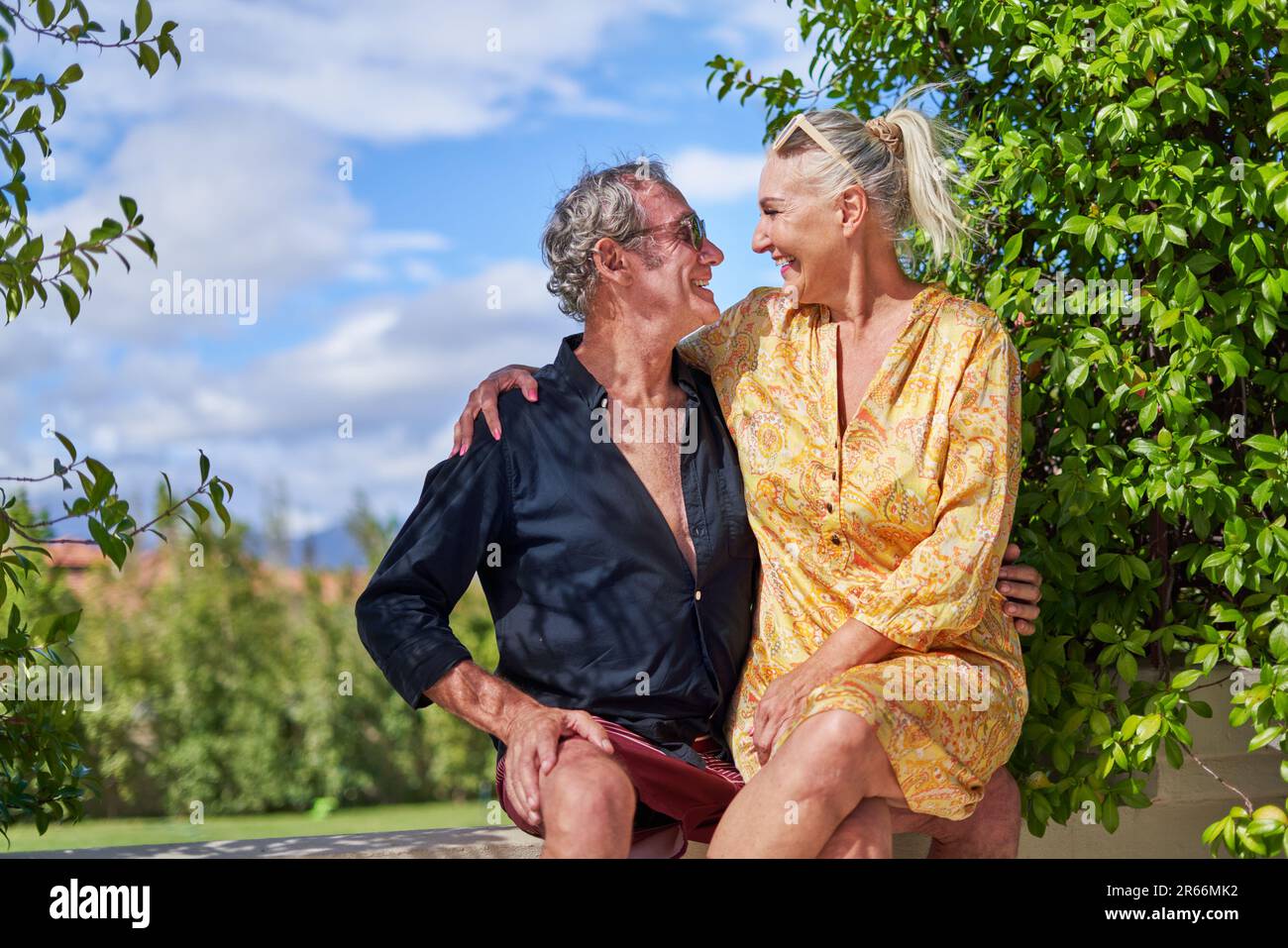 Happy, carefree senior couple hugging on summer patio Stock Photo