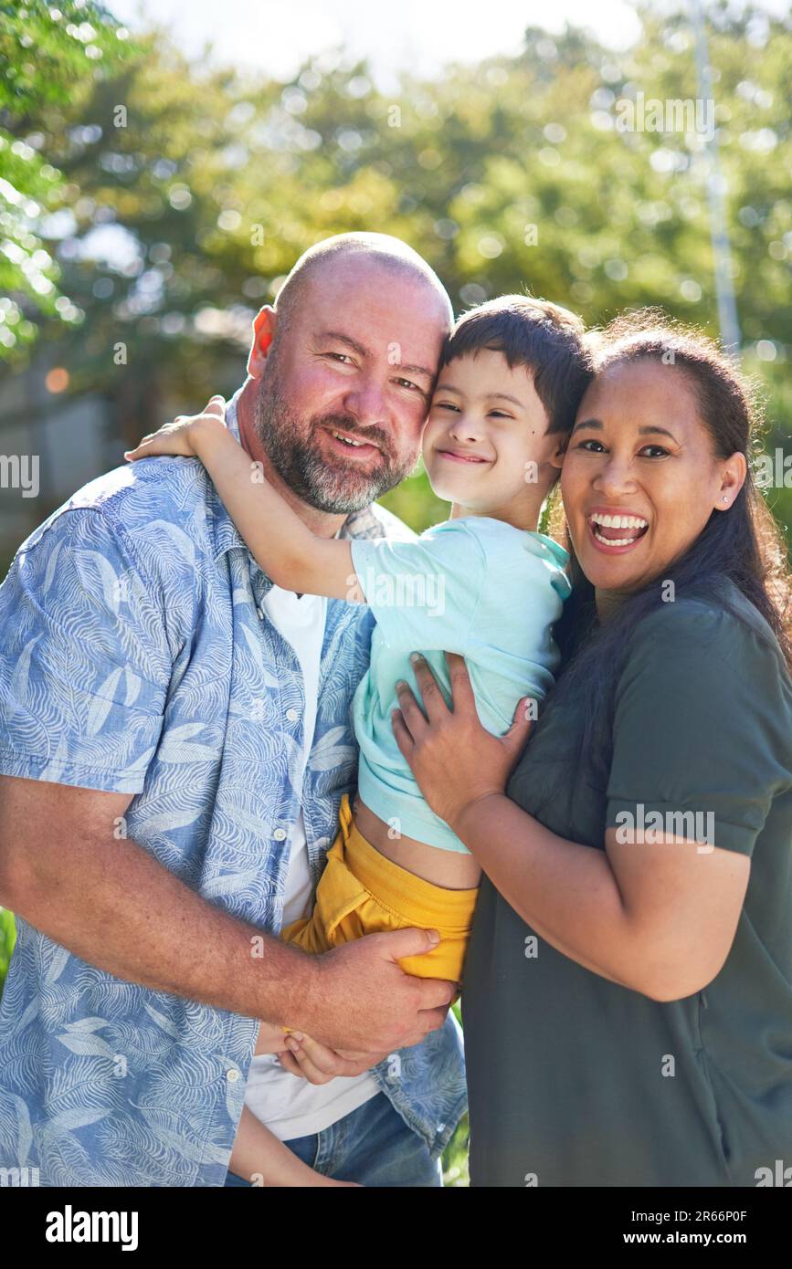 Portrait happy parents holding son with Down Syndrome Stock Photo