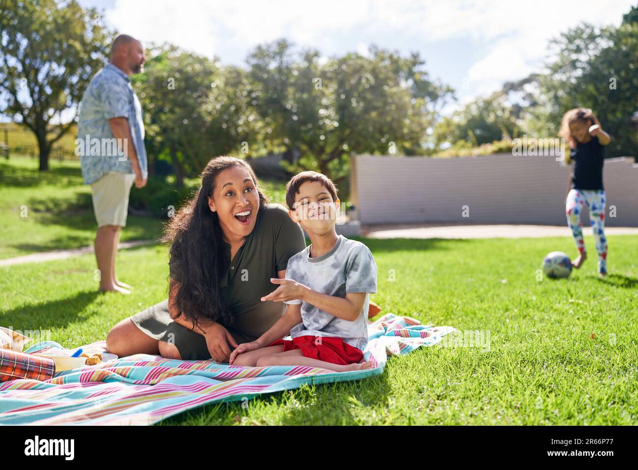 Portrait happy mother and son with Down Syndrome in sunny park Stock Photo