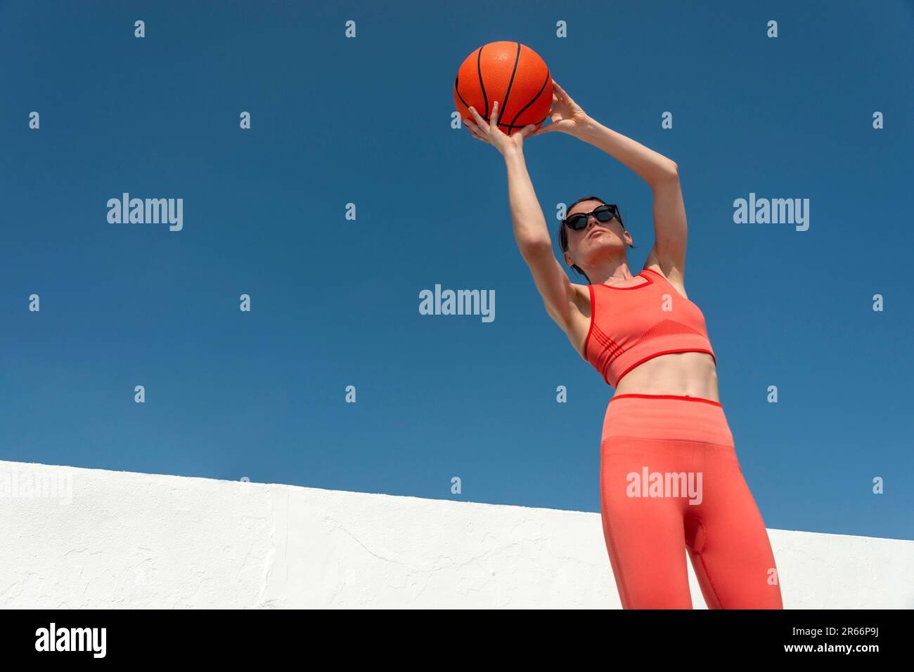 Mid adult sporty woman shooting hoops with a basketball Stock Photo Alamy
