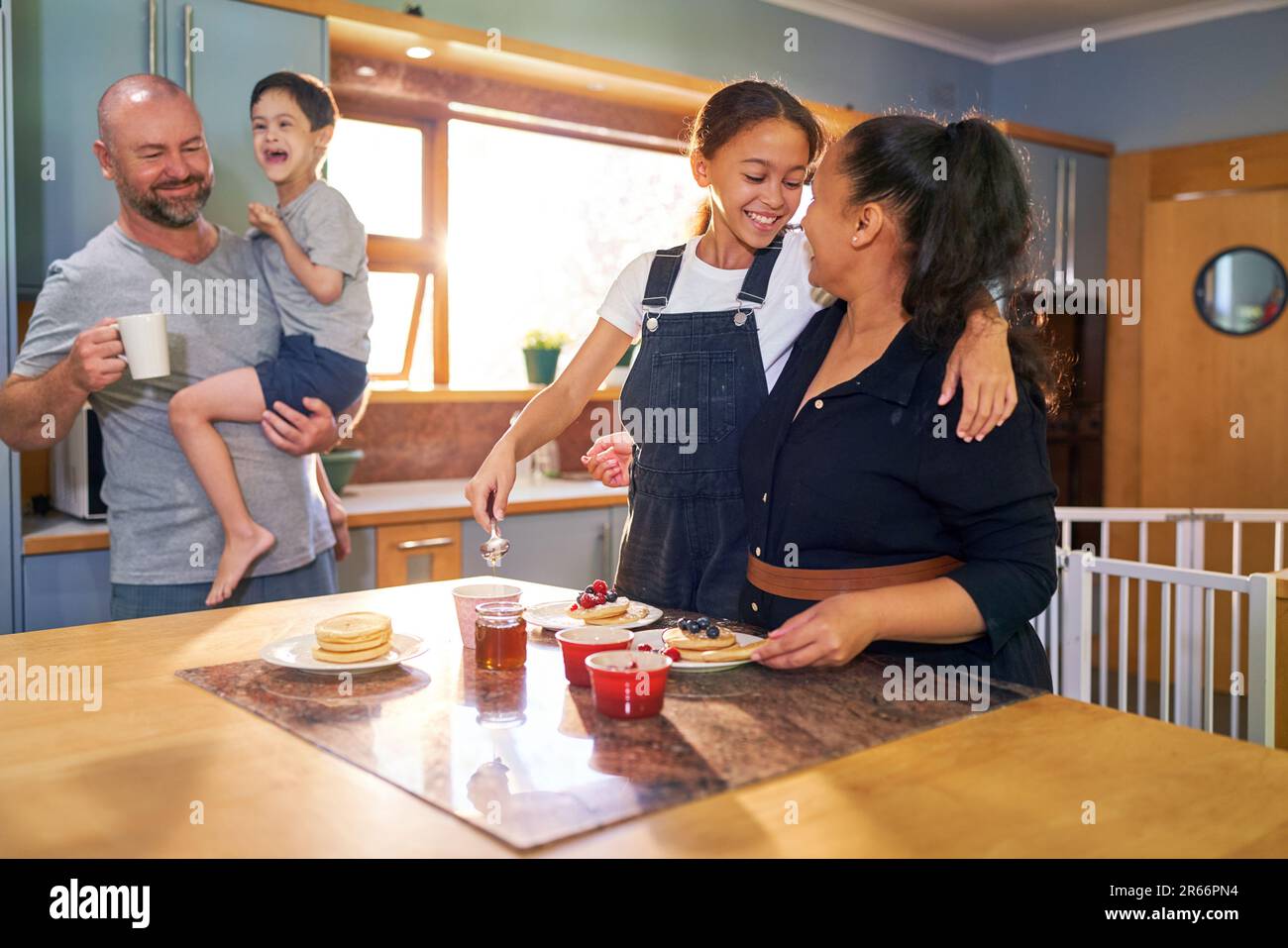 Happy family eating pancakes in morning kitchen Stock Photo