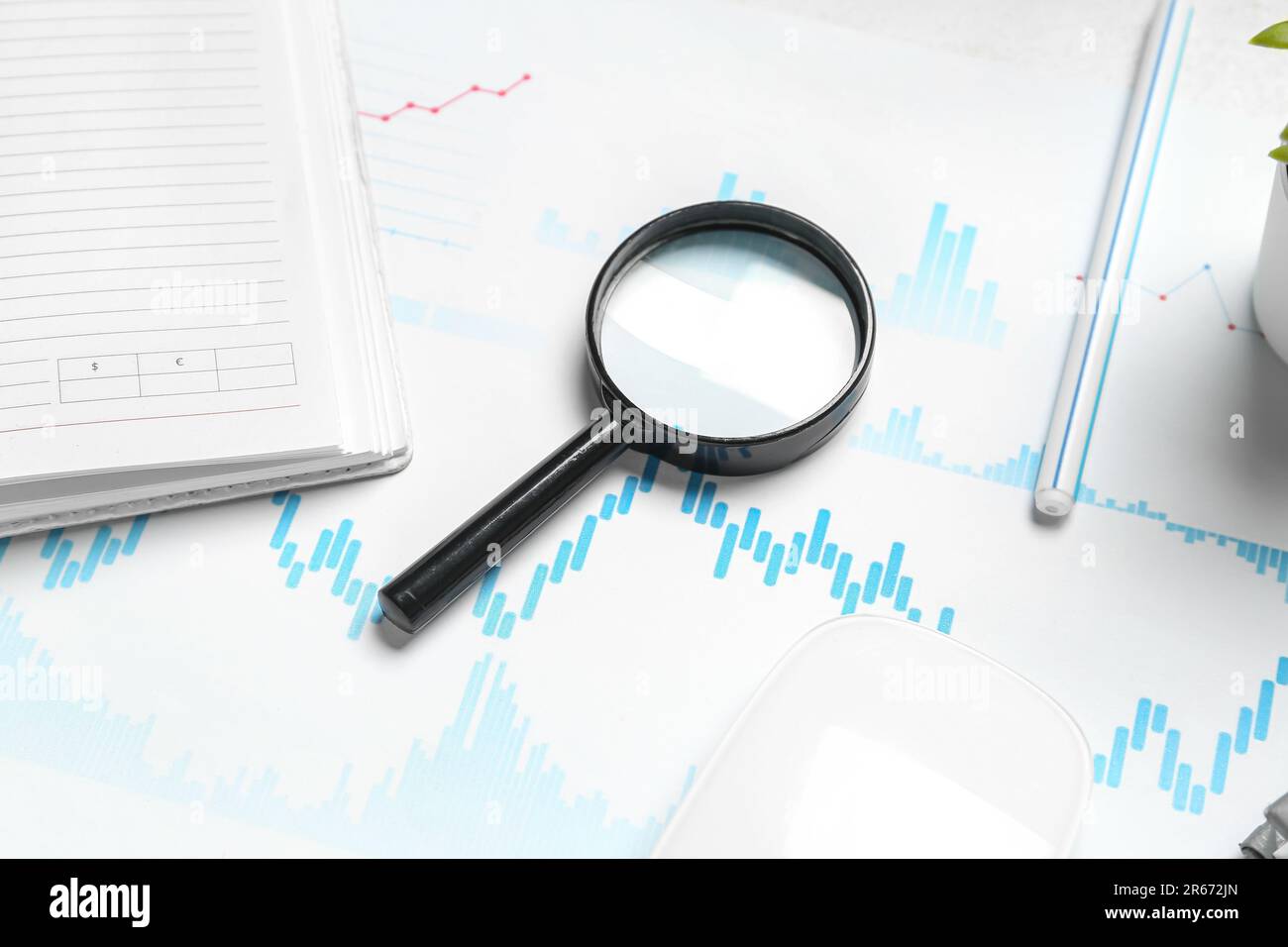 Magnifier with business charts on white table in office Stock Photo - Alamy