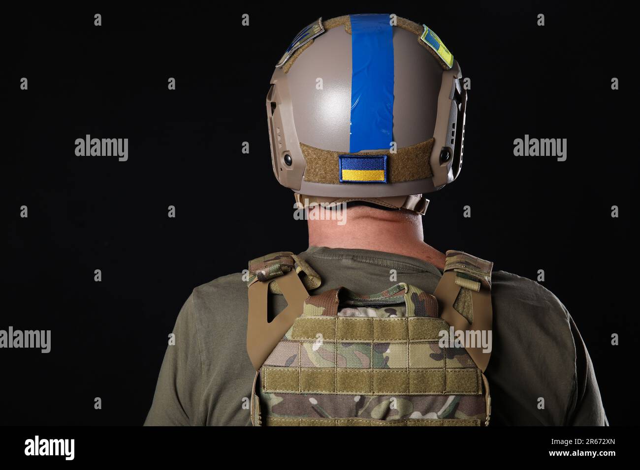 Ukrainian soldier with armor on dark background, back view Stock Photo ...