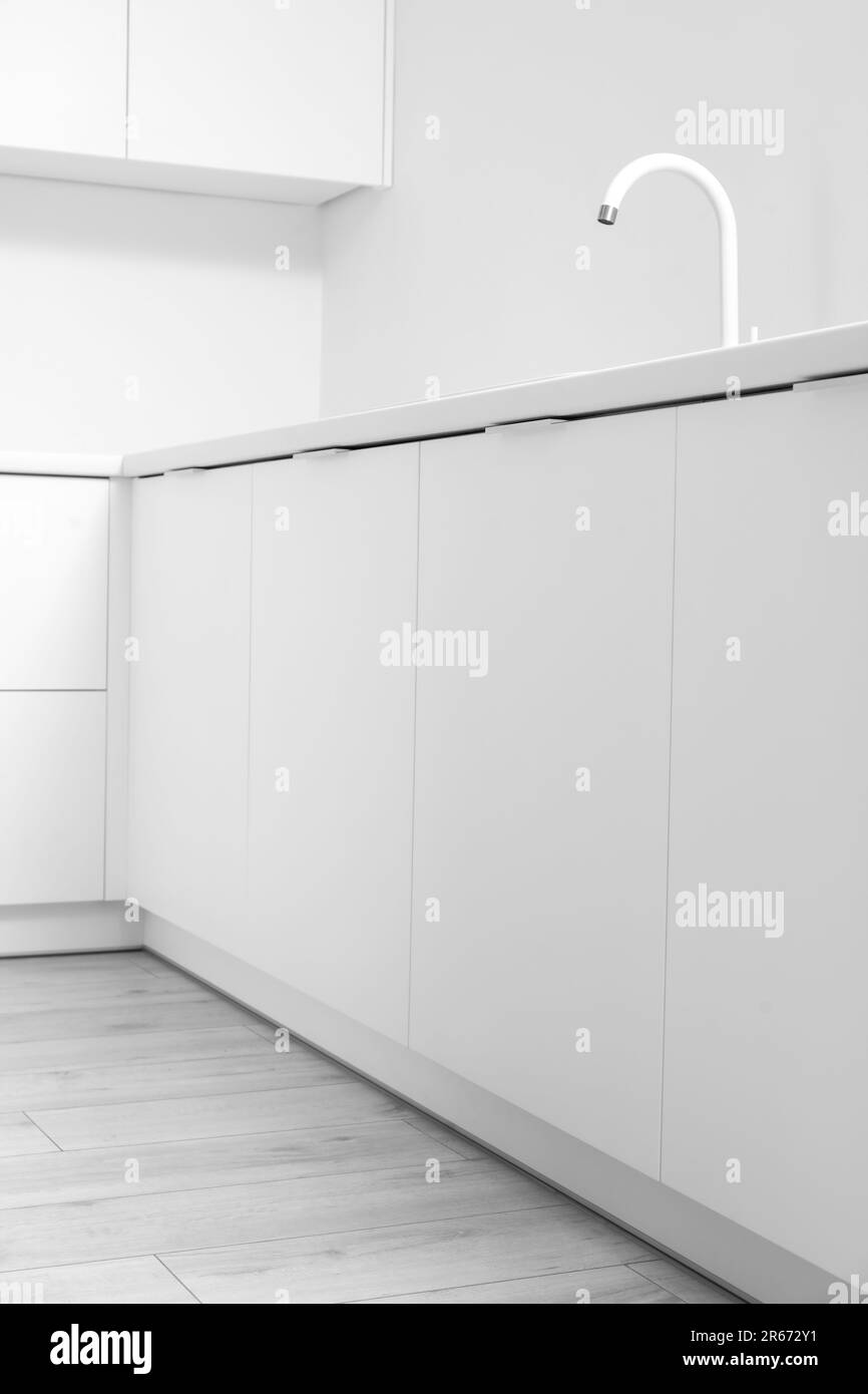 Interior of light kitchen with white drawers and sink Stock Photo Alamy