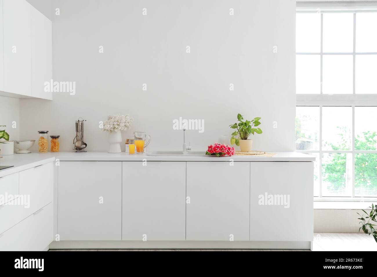Interior of light kitchen with white counters and flowers Stock Photo ...