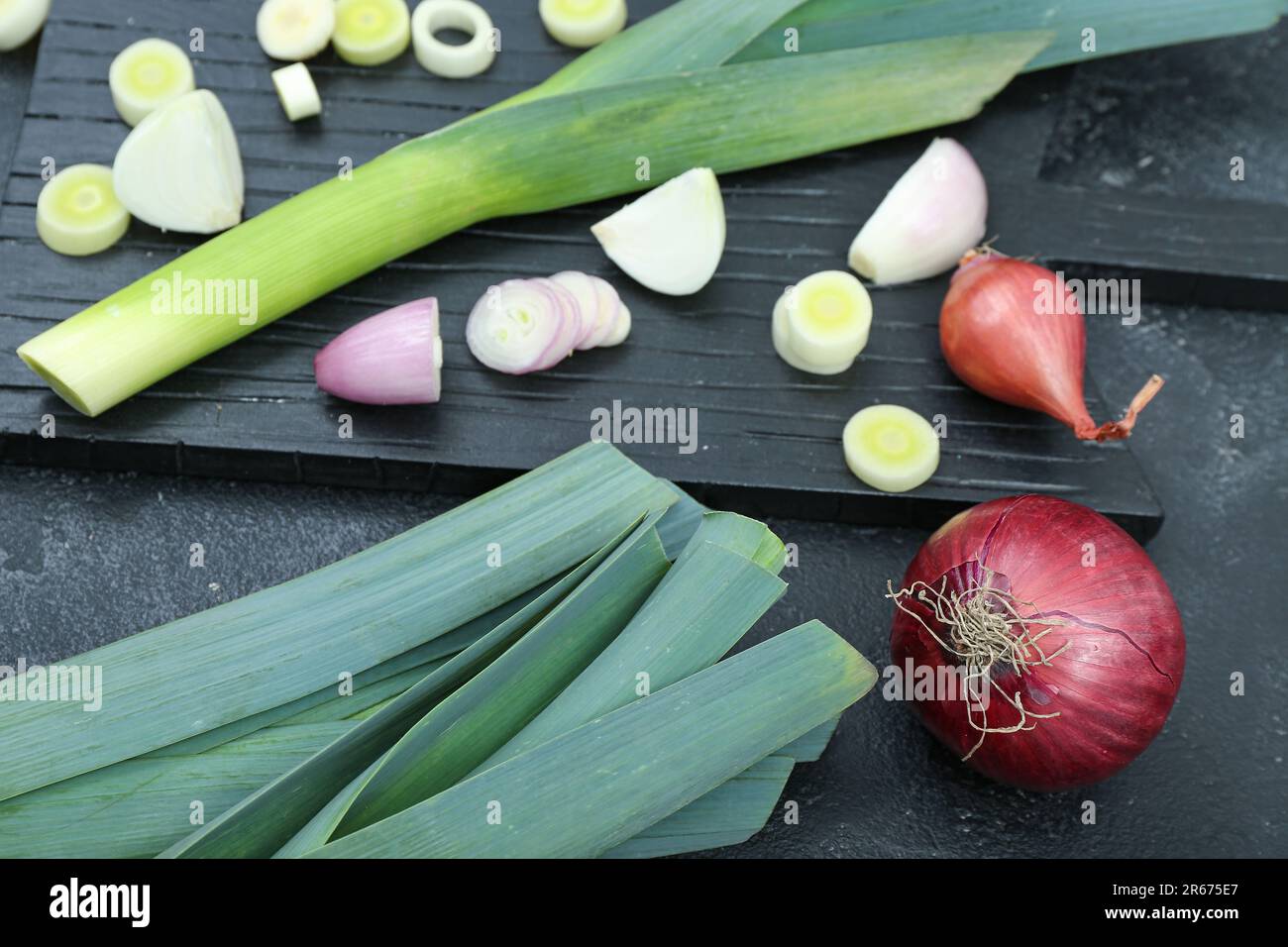 Board with different kinds of onion on grunge black background Stock ...