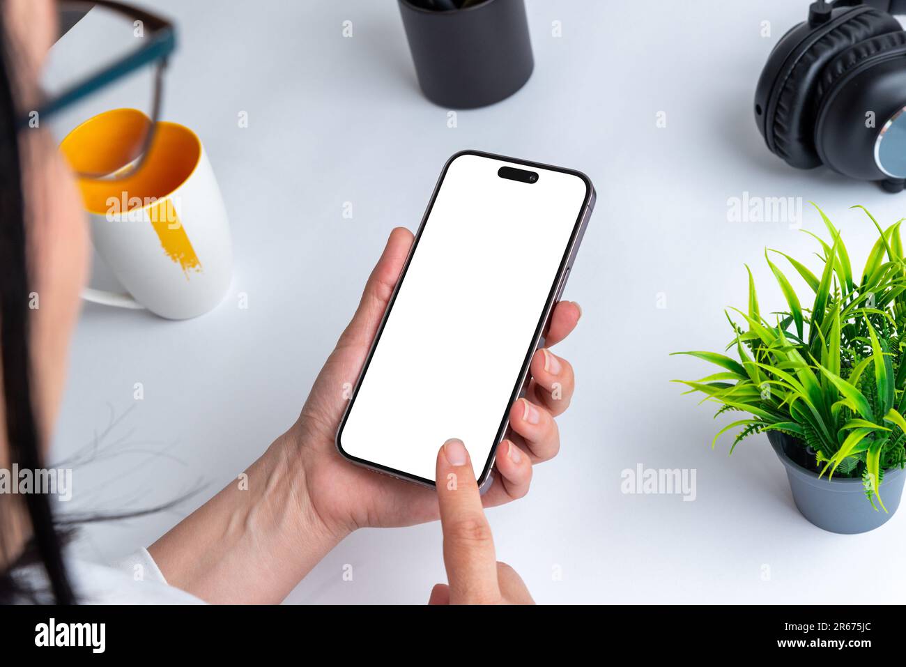 Woman touch smart phone with isolated display for mockup fort app or od web page presentation. Office desk in background Stock Photo