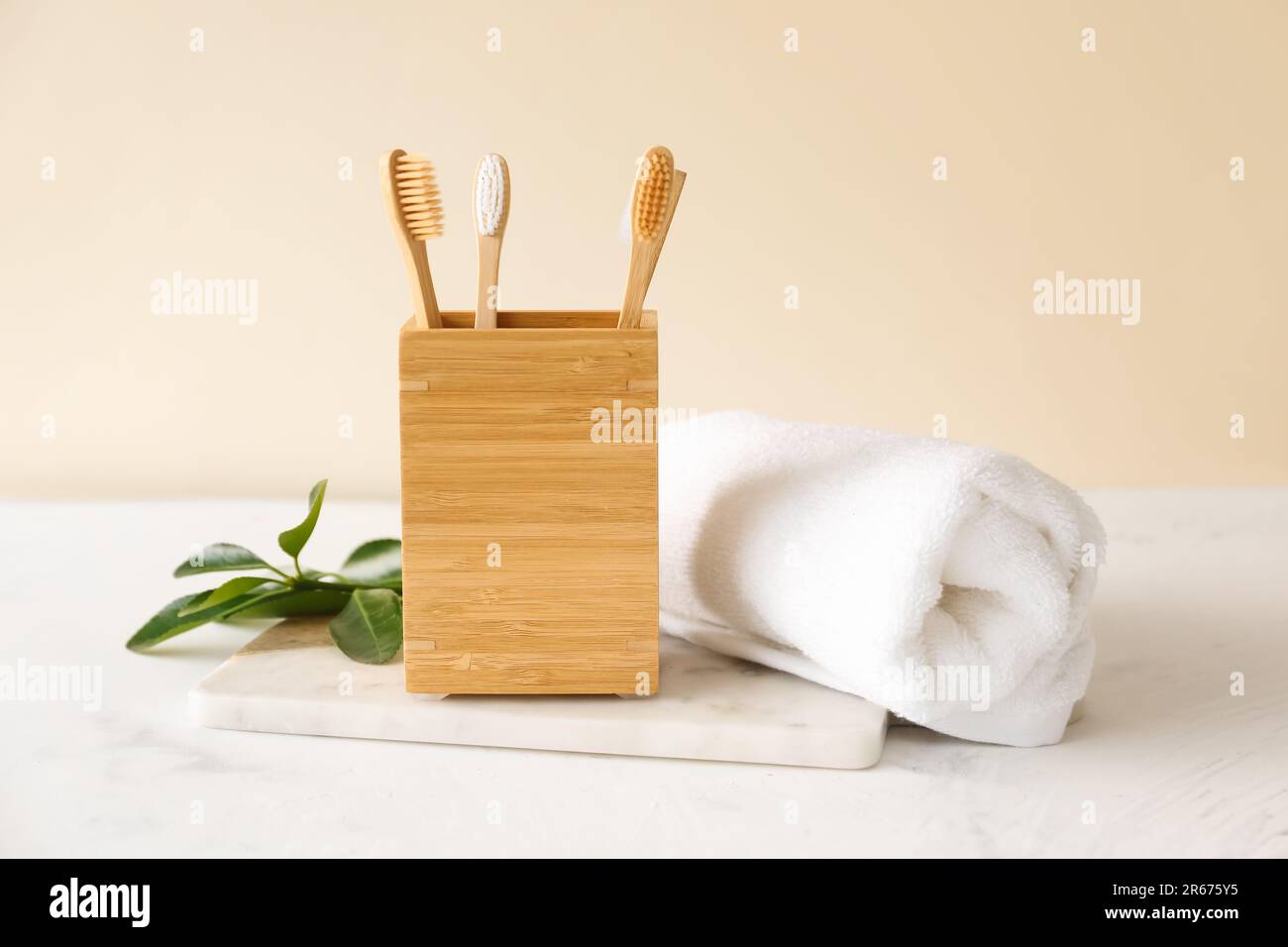 Bamboo tooth brushes in holder and towel on light background Stock ...