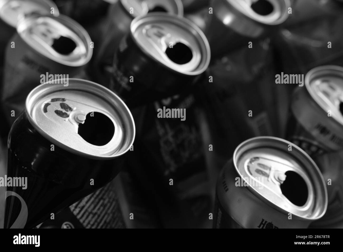 A grayscale shot of an arrangement of aluminum soda cans, each